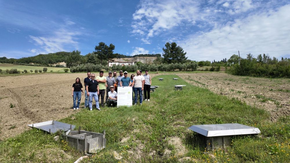 Foto di gruppo in campo durante la visita al sito sperimentale di Apiro (MC) con i docenti dell’Istituto “Cuppari-Salvati” di Jesi e i ricercatori coinvolti nelle attività L'immagine ritrae i partecipanti, in campo durante la visita, mentre posano per una foto di gruppo con i docenti dell’Istituto “Cuppari-Salvati” di Jesi e i ricercatori coinvolti nelle attività