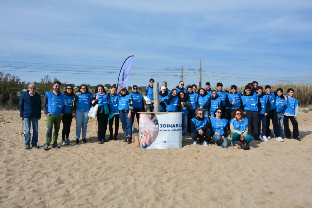 Il team joinable per il clean up: volontari, studenti e rappresentanti delle istituzioni riuniti insieme prima della raccolta L'immagine ritrae il team joinable pronti per il clean up insieme a volontari, studenti e rappresentanti delle istituzioni